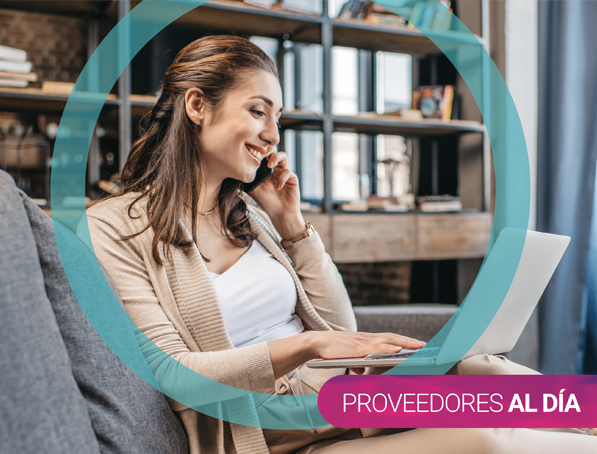 Mujer sonriendo hablando por telefono y usando su computador