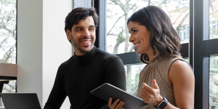 Una pareja conversando frente a sus laptops