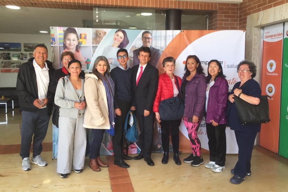familia posando frente una sedee de compensar