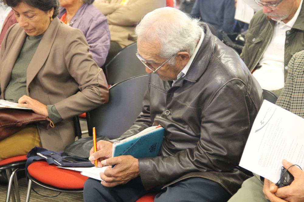 adulto mayor tomando apuntes de la presentacion